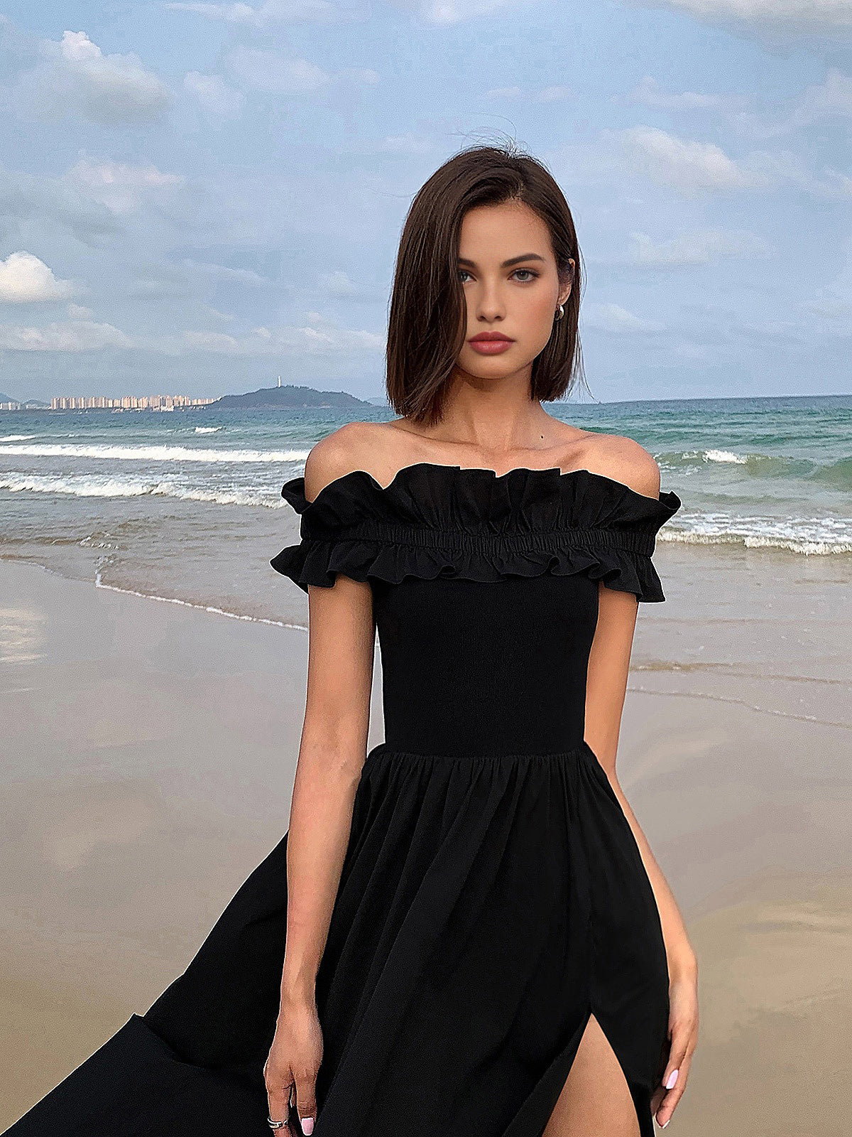 Schulterfreies, langes Kleid mit Rüschen und hohem Schlitz