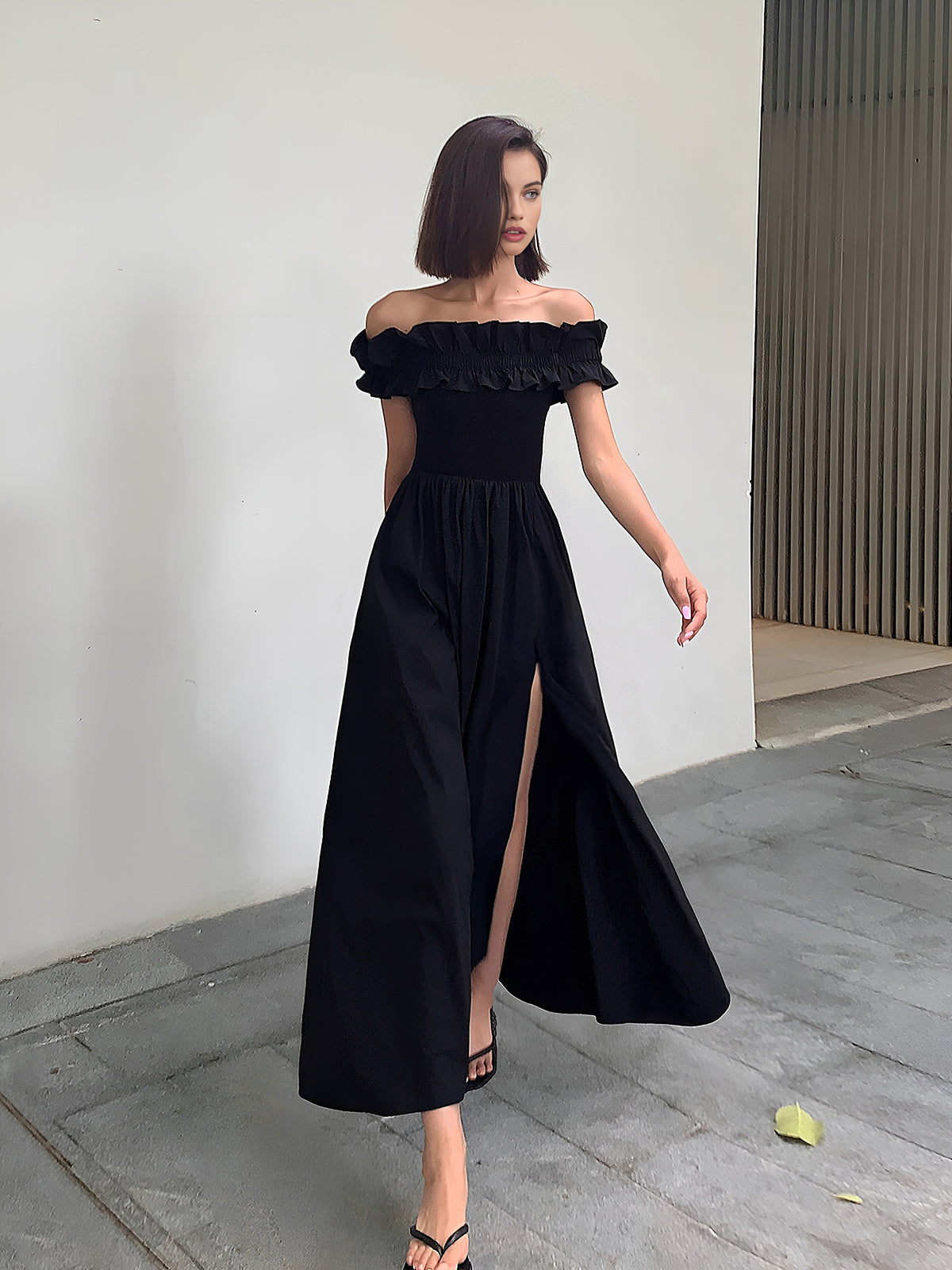 Schulterfreies, langes Kleid mit Rüschen und hohem Schlitz